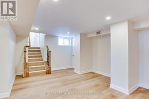 Fort Erie (Central) apartment for rent - A spacious room with wooden floors and a staircase leading to the upper level.