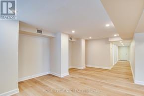 Fort Erie (Central) apartment for rent - A spacious room with wooden flooring and white walls.