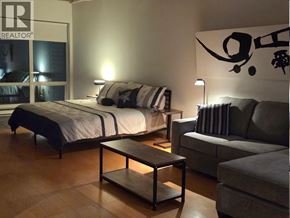Vancouver apartment for rent - A bedroom with a bed, a couch, and a coffee table.