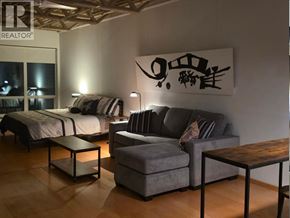 Vancouver apartment for rent - A bedroom with a bed, a couch, and a table.
