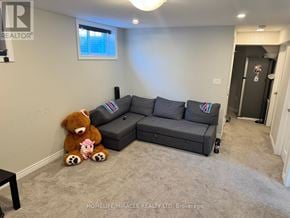Thorold (Rolling Meadows) apartment for rent - A living room with a grey couch and a teddy bear on the floor.