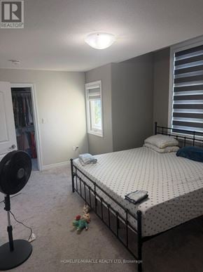 Thorold (Rolling Meadows) apartment for rent - A bedroom with a bed, a fan, and a window.