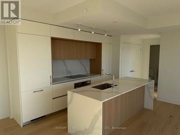 Toronto (Annex) condo for rent - A kitchen with white cabinets and a wooden backsplash.
