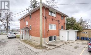 Kitchener multi-family for rent - A red brick house with a white garage door.