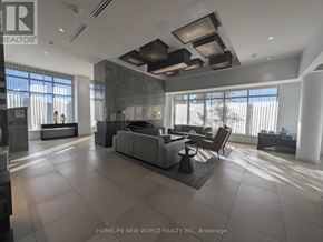 Toronto (Don Valley Village) condo for rent - A modern living room with a large grey sofa and a wooden coffee table.