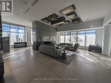 Toronto (Don Valley Village) condo for rent - A modern living room with a large grey sofa and a wooden coffee table.