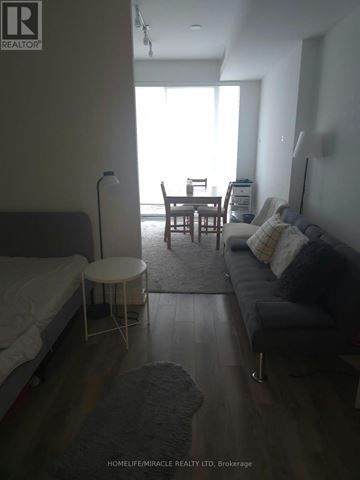 Toronto (Bay Street Corridor) condo for rent - A living room with a grey couch and a white bed.