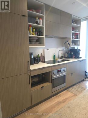 Toronto (Bay Street Corridor) condo for rent - A kitchen with wooden cabinets and appliances.