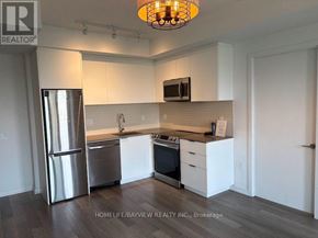 Toronto (Moss Park) condo for rent - A kitchen with white cabinets and a stainless steel refrigerator.