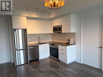Toronto (Moss Park) condo for rent - A kitchen with white cabinets and a stainless steel refrigerator.