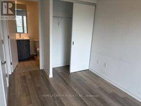 Toronto (Moss Park) condo for rent - A room with a white door and a wooden floor.