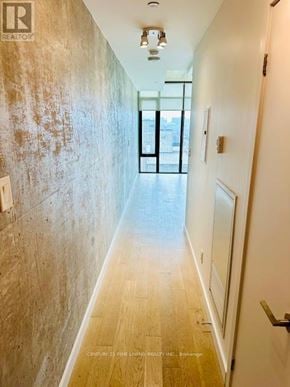 Toronto (Waterfront Communities) condo for rent - A long hallway with a door at the end.