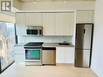 Toronto (Waterfront Communities) condo for rent - A kitchen with white cabinets and stainless steel appliances.