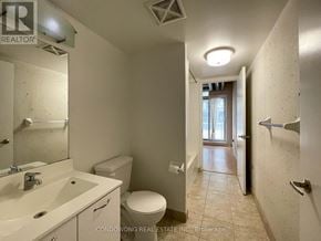 Toronto (Little Portugal) condo for rent - A bathroom with a toilet, sink, and mirror.