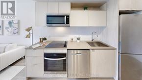 Toronto (Church-Yonge Corridor) condo for rent - A modern kitchen with a white color scheme and stainless steel appliances.