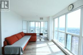 Toronto (Bendale) condo for rent - A living room with a red couch and a large window overlooking the city.