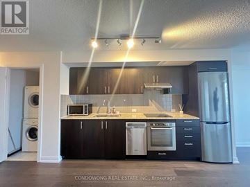 Toronto (Agincourt South-Malvern West) condo for rent - A modern kitchen with black cabinets and stainless steel appliances.