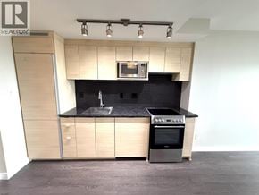 Vancouver apartment for rent - A modern kitchen with a black countertop and stainless steel appliances.