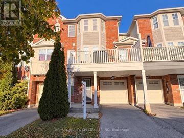 Milton (Be Beaty) townhouse for rent - A large multi-story apartment building with a balcony and a small tree in front.