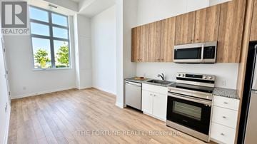 Waterloo condo for rent - A kitchen with wooden cabinets and a window.