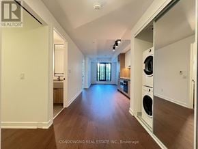 Toronto (Forest Hill South) condo for rent - A spacious, well-lit room with wood flooring and a washer and dryer in the corner.