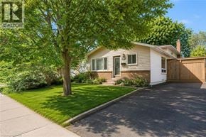 Guelph apartment for rent - A house with a white garage door and a brown fence.