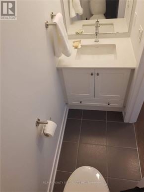 Vaughan (Sonoma Heights) townhouse for rent - A white toilet is in a small bathroom with a sink and mirror.