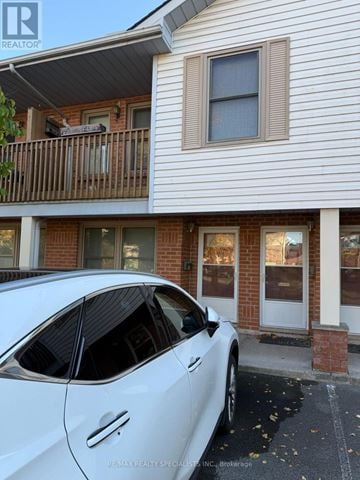 St. Catharines (Oakdale) condo for rent - A white car is parked in front of a house with a sign that says RE/MAX REALTY SPECIALISTS, INC. Brokerage.