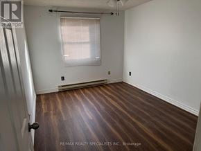 St. Catharines (Oakdale) condo for rent - A room with wooden flooring and a window with blinds.
