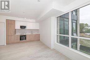 Mississauga (Lakeview) condo for rent - A modern kitchen with wooden cabinets and a large window.