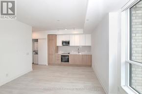 Mississauga (Lakeview) condo for rent - A modern kitchen with white walls and wooden cabinets.