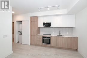 Mississauga (Lakeview) condo for rent - A modern kitchen with white cabinets and a wooden island.
