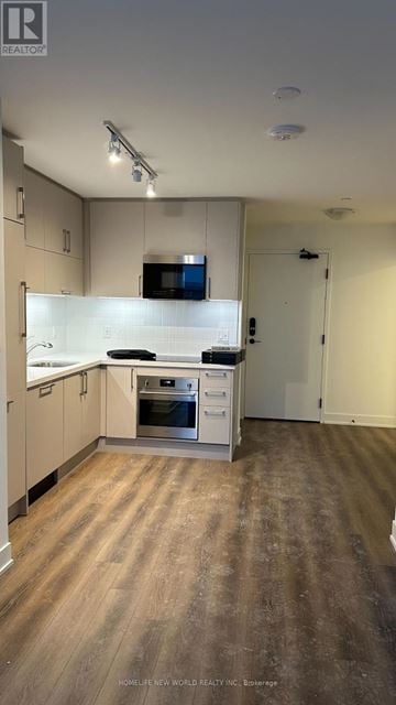 Markham (Unionville) condo for rent - A kitchen with wooden floors and white cabinets.
