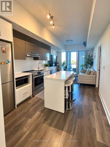 Toronto (Don Valley Village) condo for rent - A modern kitchen with wooden flooring and stainless steel appliances.