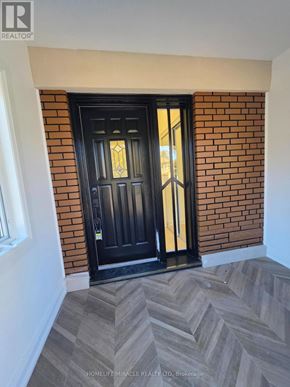 Toronto (Bendale) multi-family for rent - A black door with a glass window is set in a brick wall.