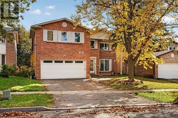 Richmond Hill (South Richvale) apartment for rent - A red brick house with a white garage door and a tree with yellow leaves.