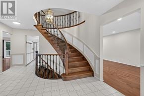 Richmond Hill (South Richvale) apartment for rent - A large, open living space with a curved staircase and a chandelier.