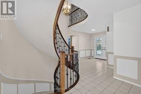 Richmond Hill (South Richvale) apartment for rent - A spiral staircase in a home with a light brown wooden banister.