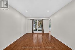 Richmond Hill (South Richvale) apartment for rent - A spacious room with wooden floors and white walls.