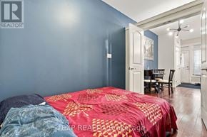 Kitchener townhouse for rent - A bedroom with a bed covered in a red and gold comforter.