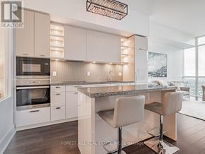 Toronto (Annex) condo for rent - A modern kitchen with a large island and bar stools.