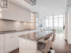 Toronto (Annex) condo for rent - A modern kitchen with granite countertops and white cabinets.