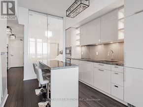 Toronto (Annex) condo for rent - A modern kitchen with white cabinets and a central island.