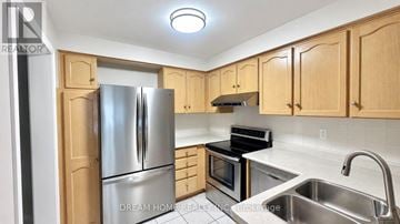Richmond Hill (Rouge Woods) townhouse for rent - A kitchen with wooden cabinets and stainless steel appliances.