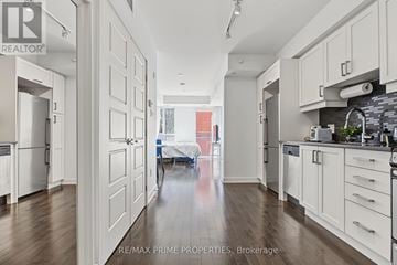 Ottawa condo for rent - A spacious kitchen with white cabinets and a dining area in the background.