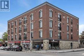 Ottawa condo for rent - A brick building with a parking lot in front of it.