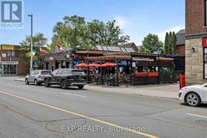 Ottawa condo for rent - A street view with cars parked on the side of the road and a building with a red awning in the background.