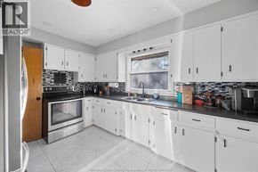 Windsor apartment for rent - A kitchen with white cabinets and a black counter top.