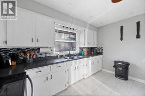 Windsor apartment for rent - A kitchen with white cabinets and black countertops.