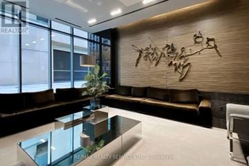Toronto (Bay Street Corridor) condo for rent - A modern living room with a glass table and a brown couch.